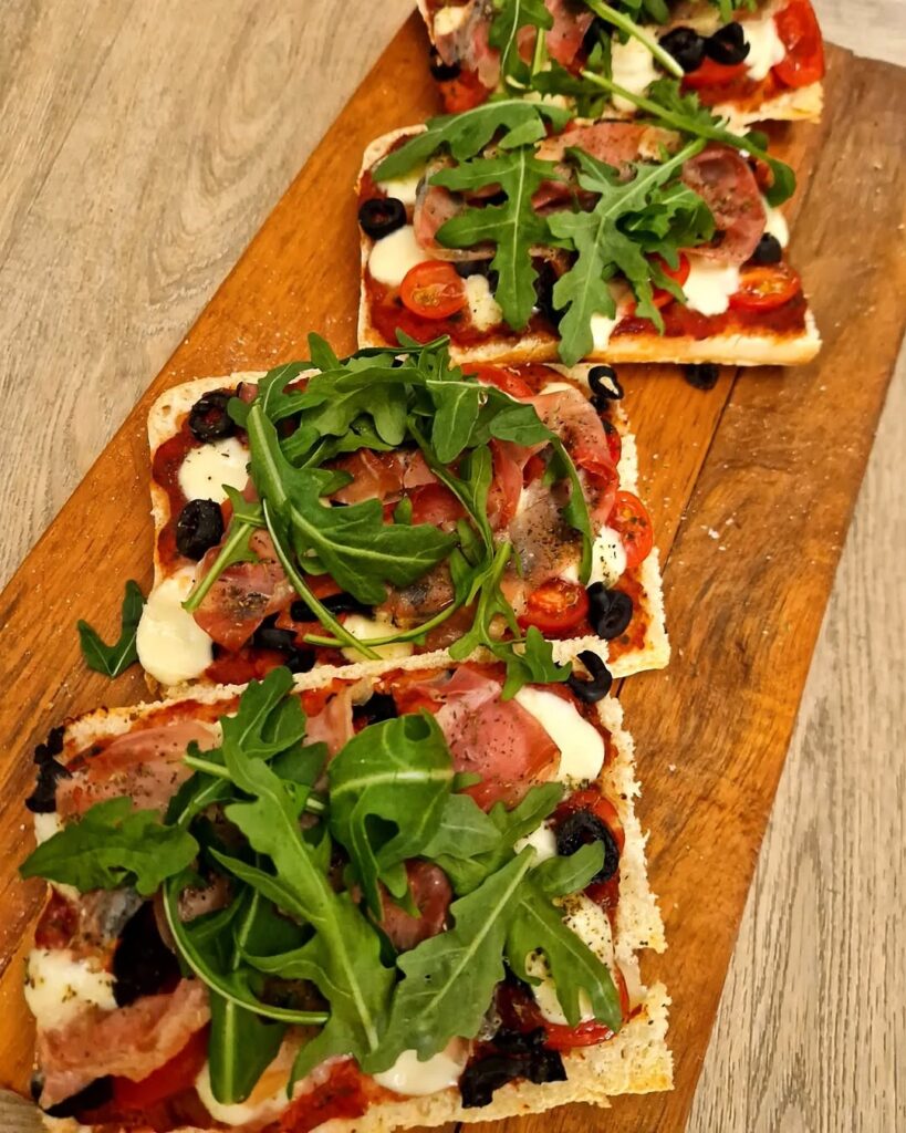 Pizza ciabatta met parmaham en zwarte olijven